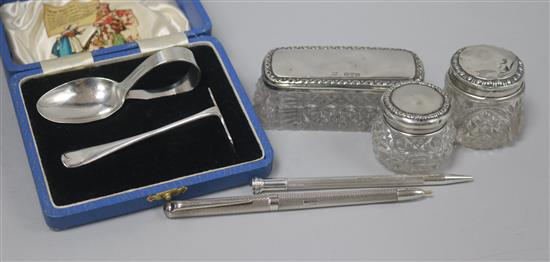 A cased 1930s silver spoon and pusher, three silver topped bottles and an engine turned silver pen and pencil.